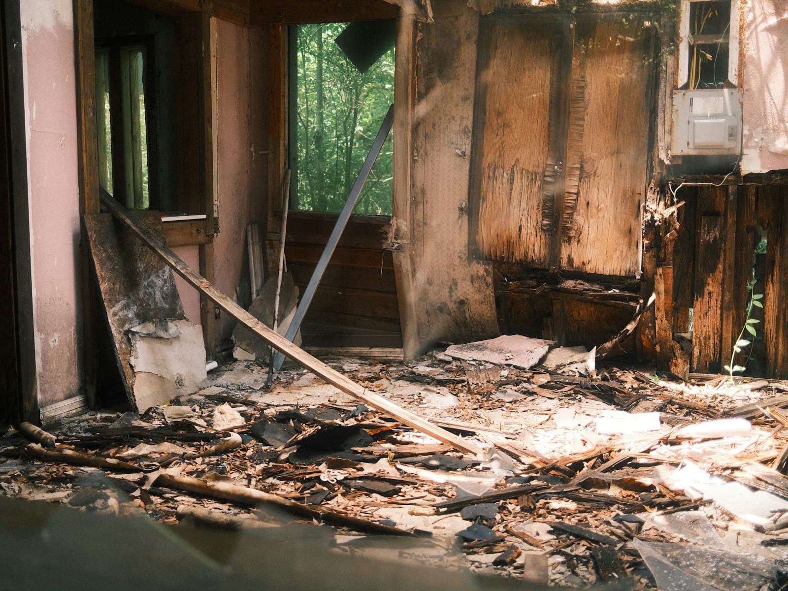 A room after a fire, walls and contents blackened and heat-damaged.