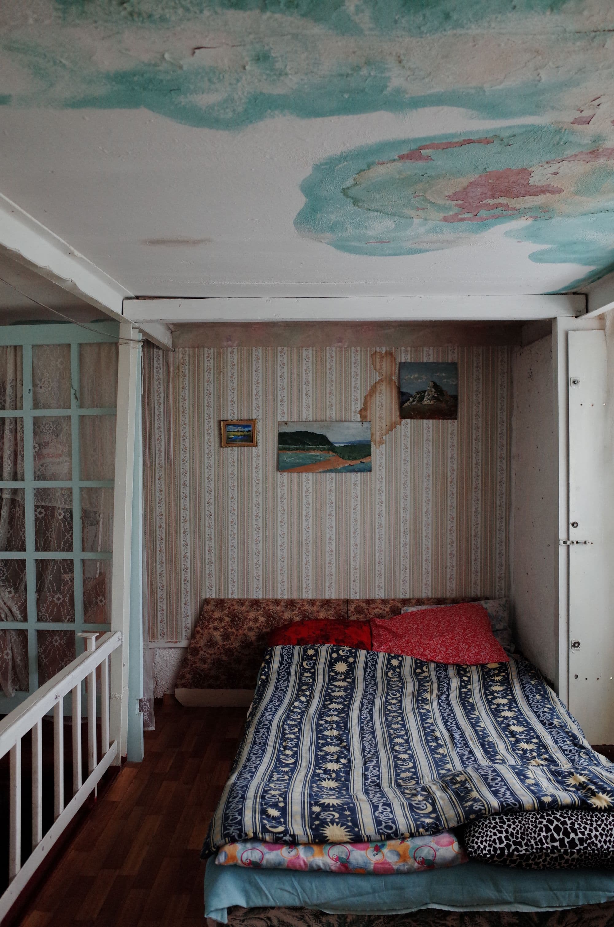 Brown water stains spreading across a bedroom ceiling near the wall junction.